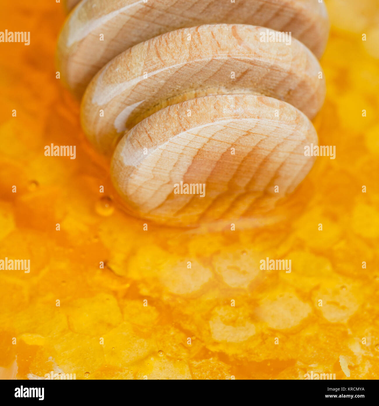 Il miele in legno stick su honeycomb close up Foto Stock