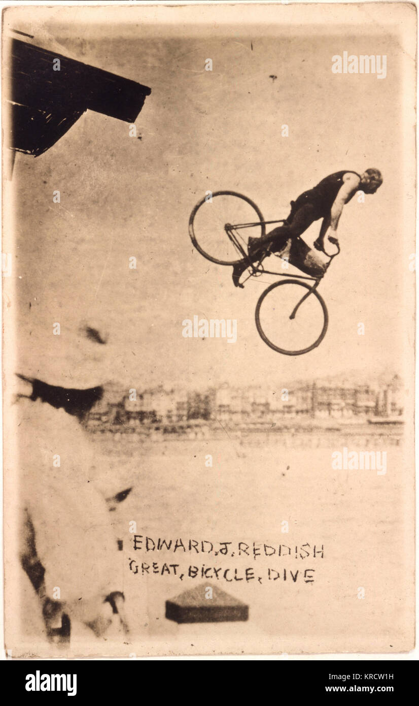 Edward J rossastro esegue la sua grande bicicletta tuffo fuori il molo a Worthing Sussex. Data: 1920s Foto Stock