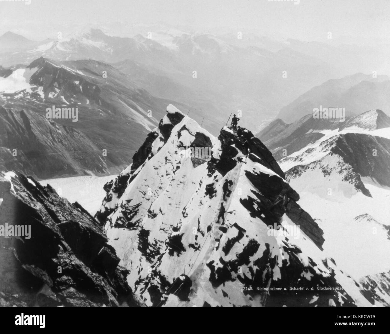 Un scalatore sorge al vertice della Glocknerspitze, nelle Alpi austriache. Data: agli inizi del XX secolo Foto Stock