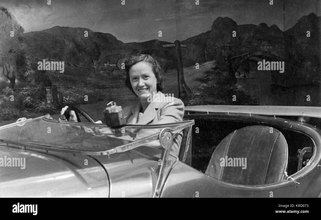 Giovane donna al volante dell'auto in studio foto Foto Stock