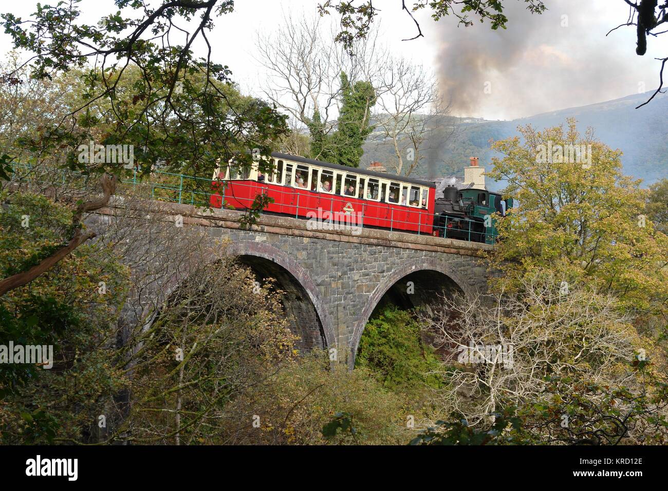 Vista della Snowdon Mountain Railway che attraversa un ponte a Waterfall Halt appena sopra la città di Llanberis nel Gwynedd, Galles del Nord. Dalla stazione di Llanberis il treno passa per la cascata e inizia la ripida salita fino alla cima di Snowdon. I passeggeri possono essere visti all'interno della carrozza, guardando il paesaggio. Foto Stock