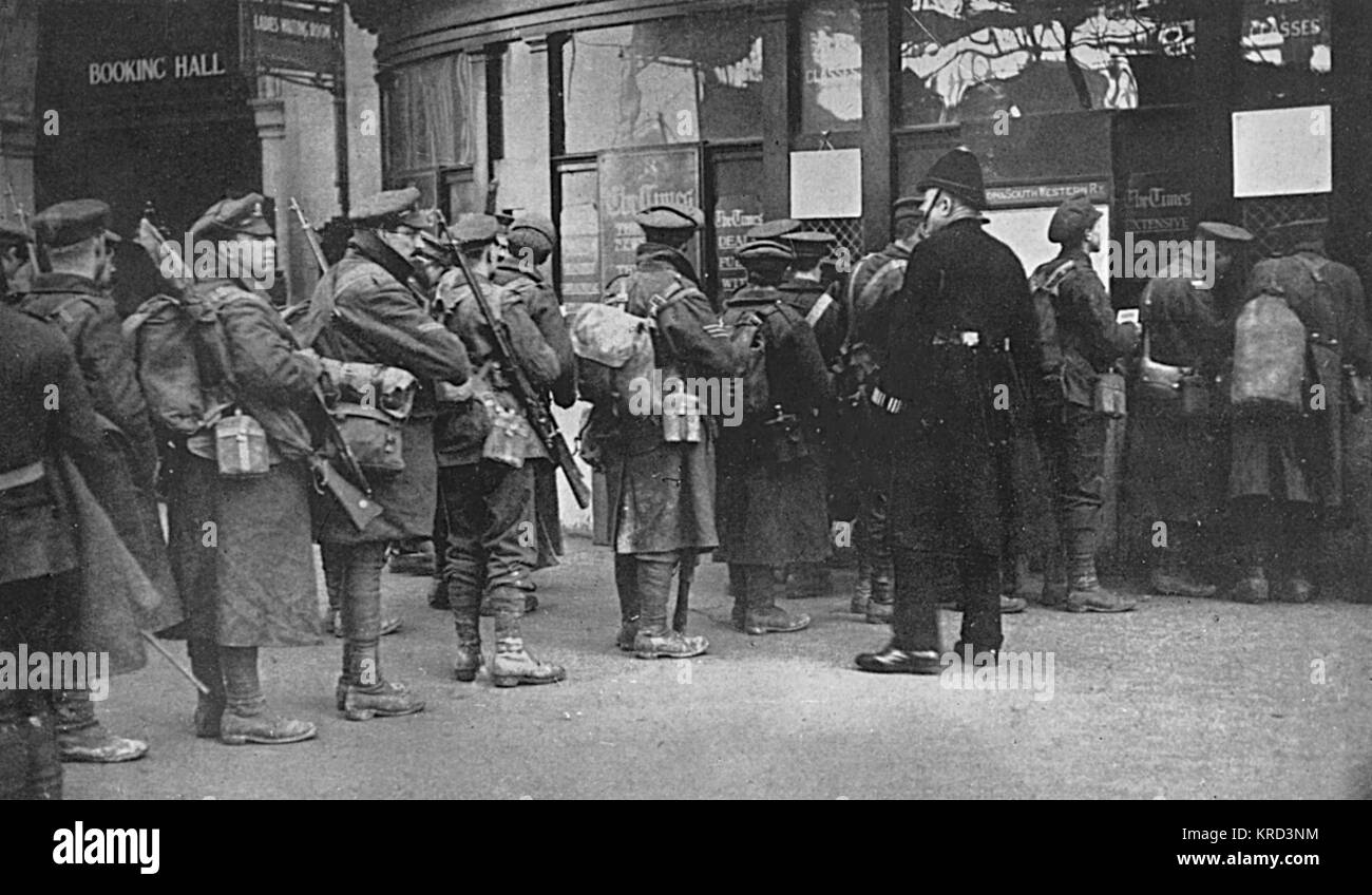 Truppe appena arrivati alla stazione di Waterloo dalle trincee acquisto biglietti presso l'ufficio prenotazioni per i viaggi per le loro case suburbane. Una tipica scena a Londra stazioni del treno durante la Prima Guerra Mondiale. Data: 1914 Foto Stock