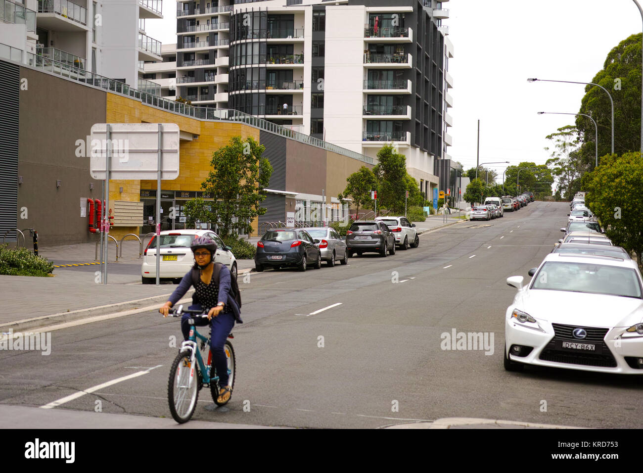 RHODES, Sydney, Nuovo Galles del Sud, Australia, 15 dicembre 2017: Donna ciclismo su strada del moderno sobborgo di Rodi a Sydney, in Australia. Foto Stock