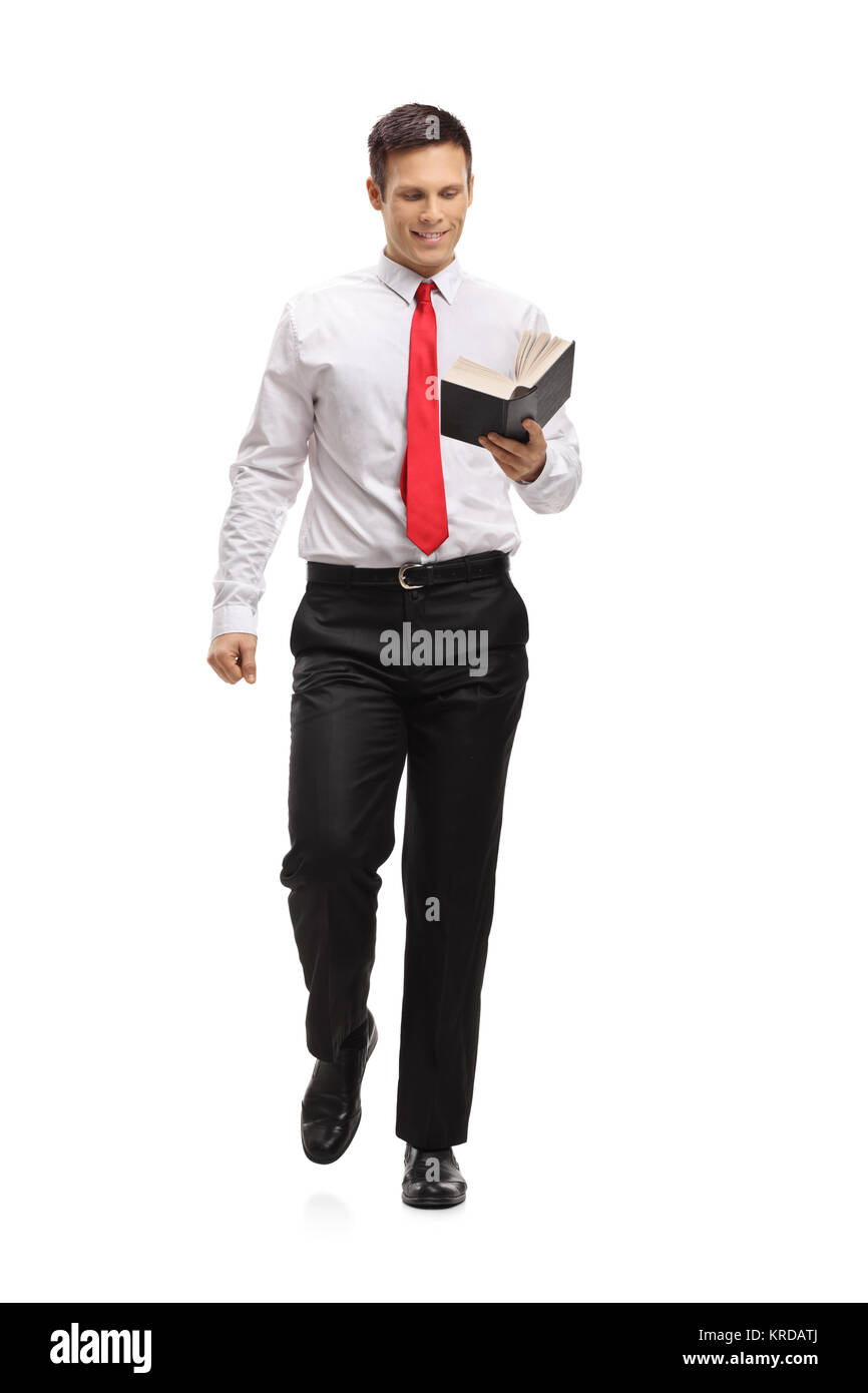A piena lunghezza Ritratto di un elegante uomo a camminare e la lettura di un libro isolato su sfondo bianco Foto Stock