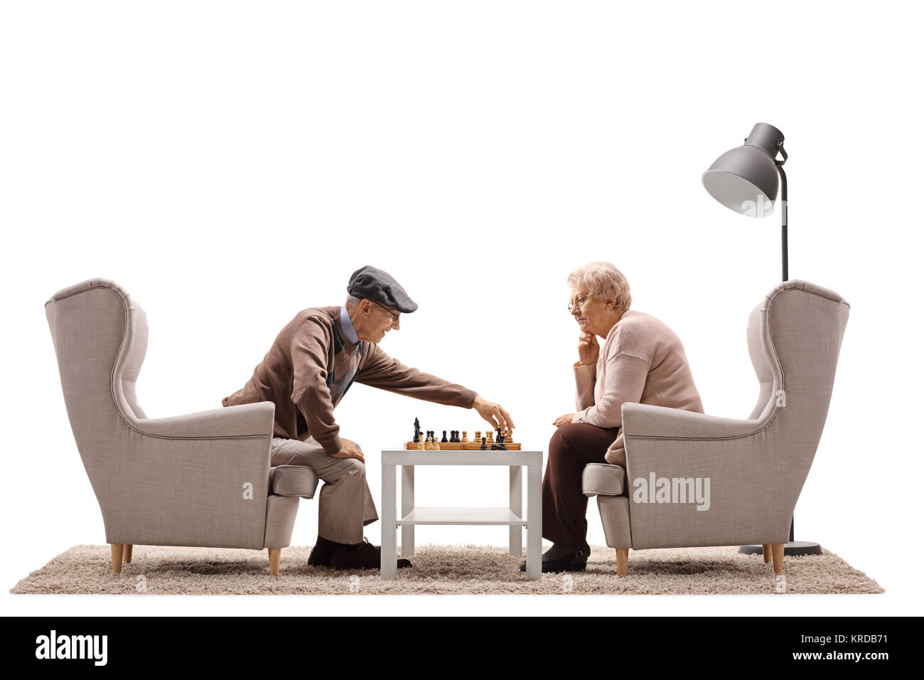 Gli anziani seduti in poltrona e giocare a scacchi isolati su sfondo bianco Foto Stock
