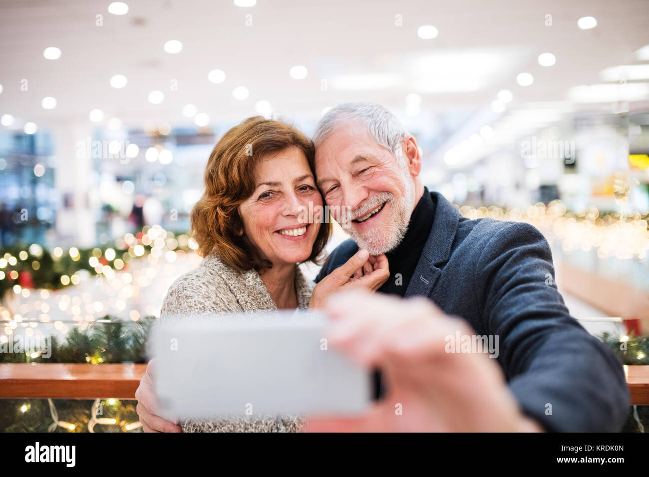 Coppia senior con lo smartphone facendo shopping di Natale. Foto Stock