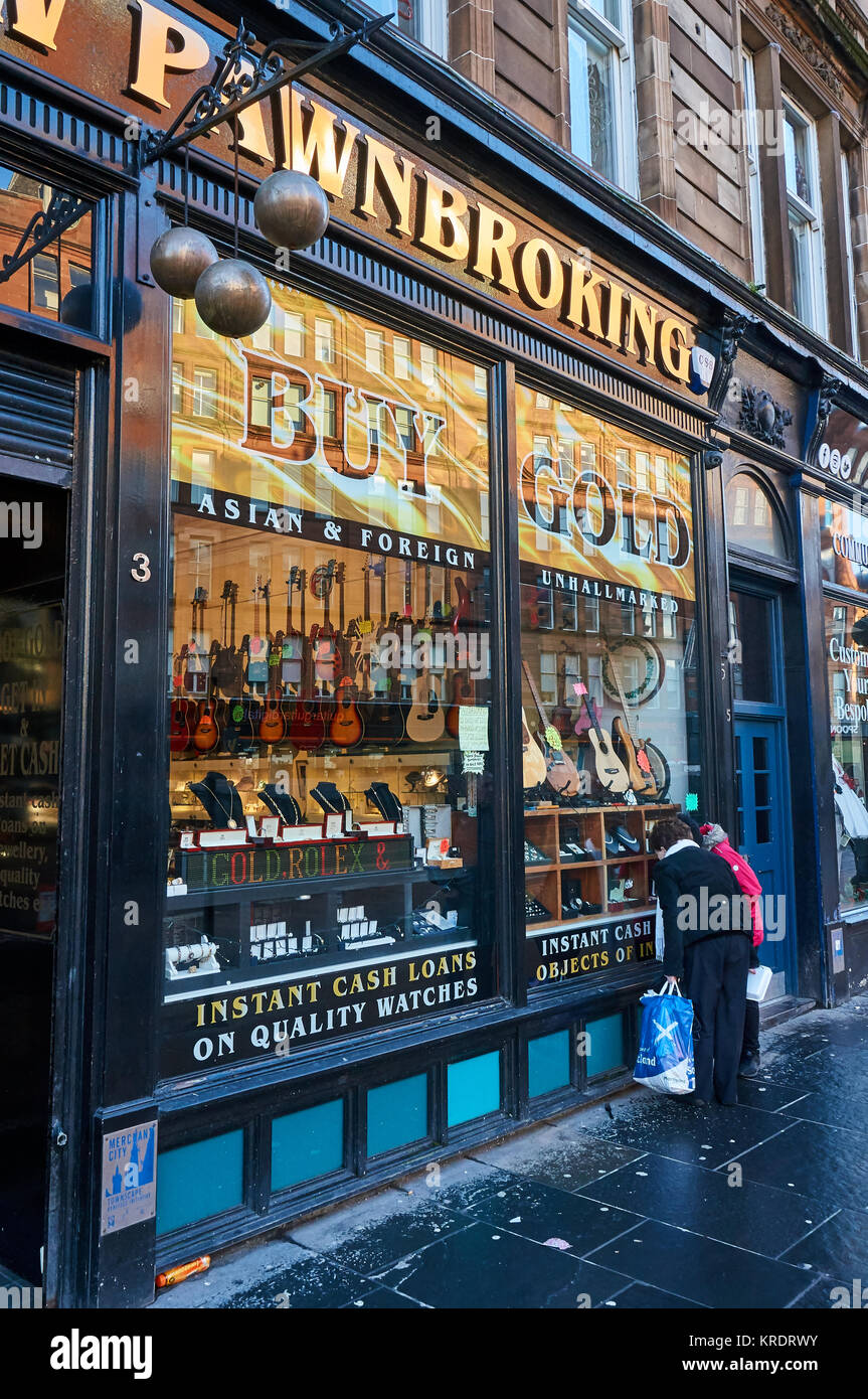 Persone che guardano la finestra di un pawnbroker a Glasgow, in Scozia. Foto Stock