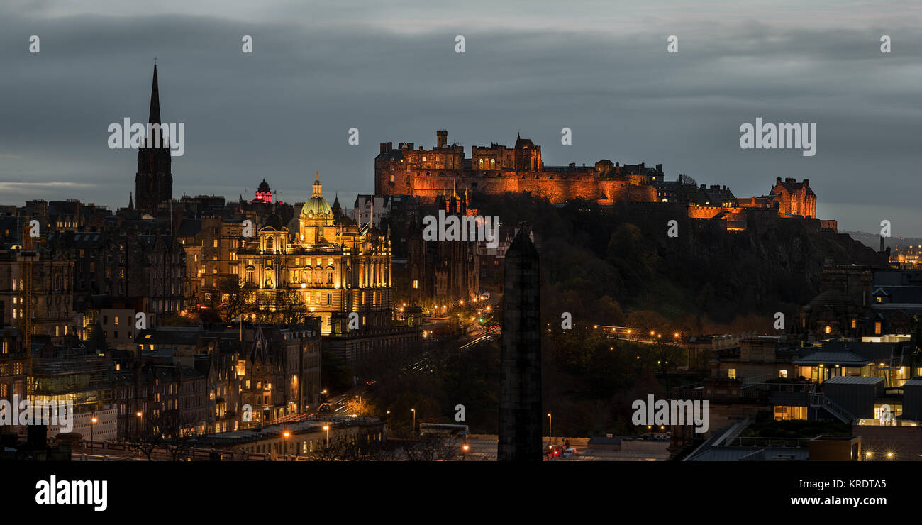 Guardando oltre la città di Edimburgo al tramonto con il Castello di Edimburgo sulla sommità di Castle Rock lite fino a distanza come visto dal Carlton Hill. Foto Stock