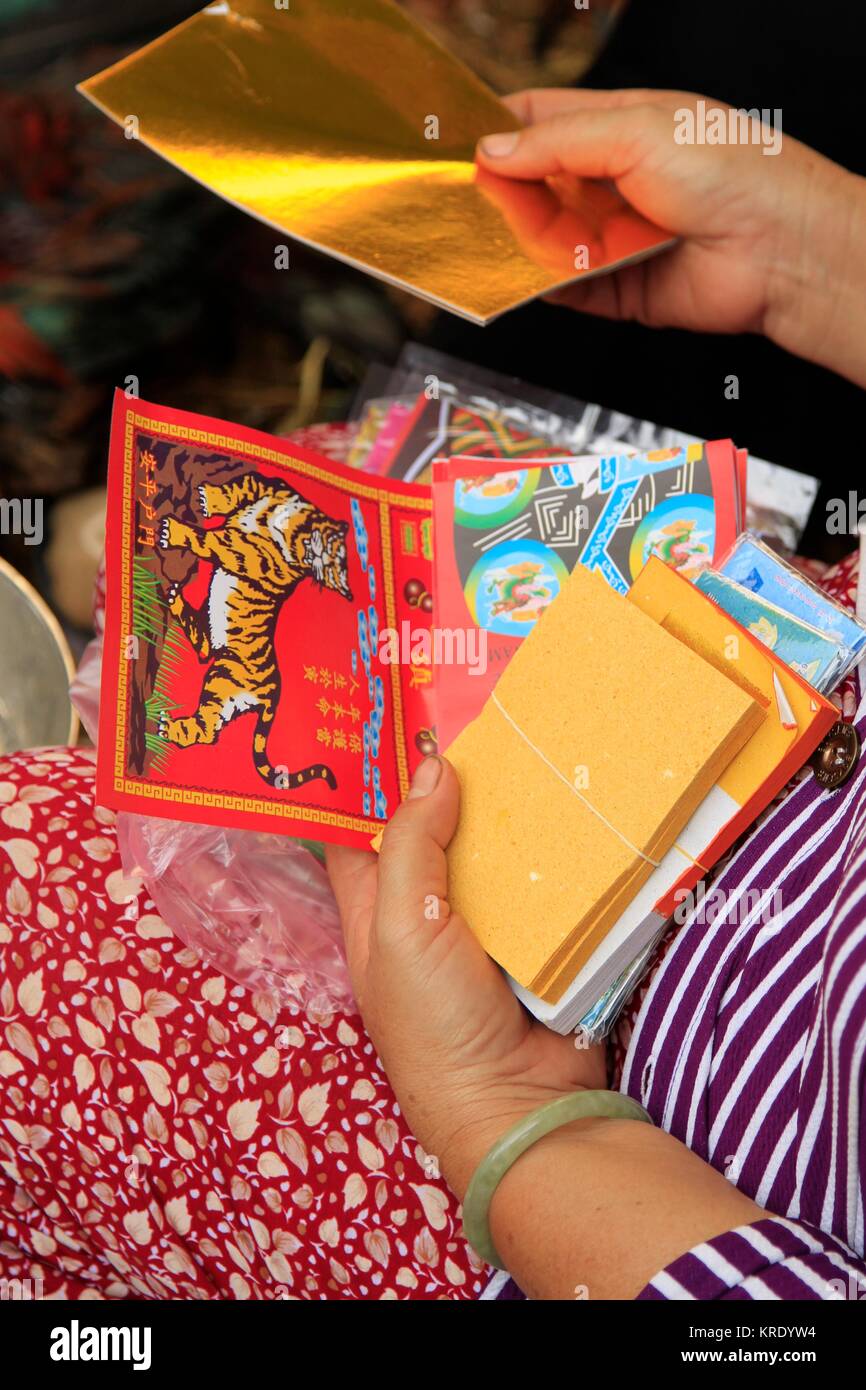 Ordinamento della donna attraverso i calendari in un mercato vietnamita in stallo, Delta del Mekong Foto Stock