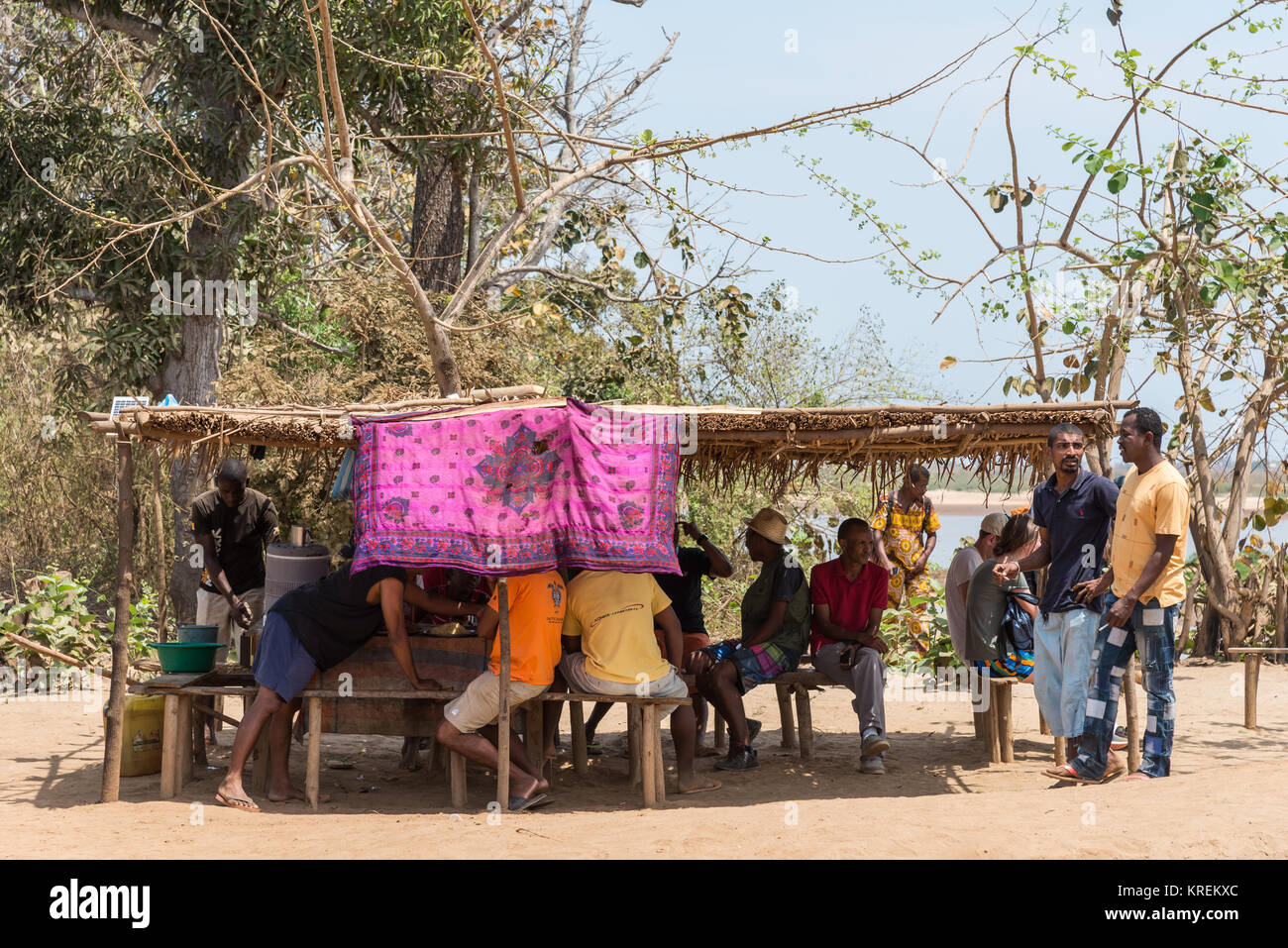 Pressione di stallo di cibo che serve i passeggeri al porto dei traghetti di Mania fiume. Madagascar, Africa. Foto Stock
