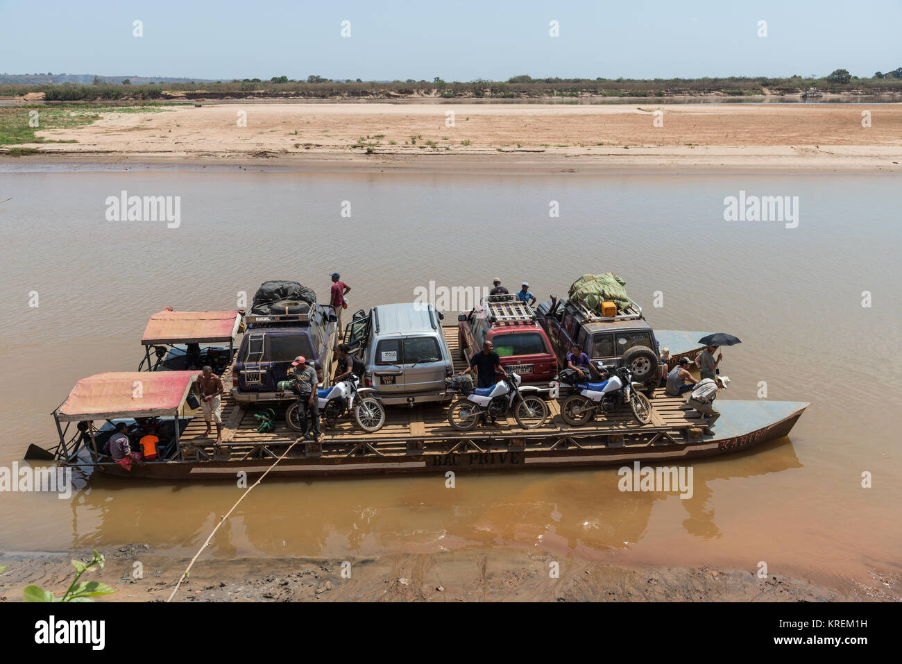I suv e i passeggeri a bordo del traghetto per attraversare il fiume Mania. Madagascar, Africa. Foto Stock