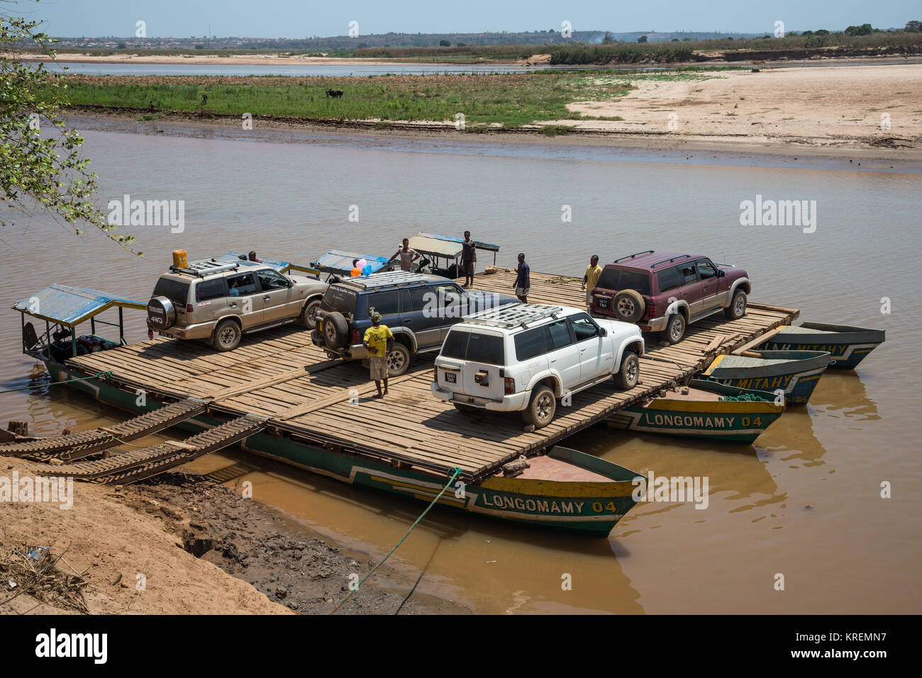 I suv e i passeggeri a bordo del traghetto per attraversare il fiume Mania. Madagascar, Africa. Foto Stock