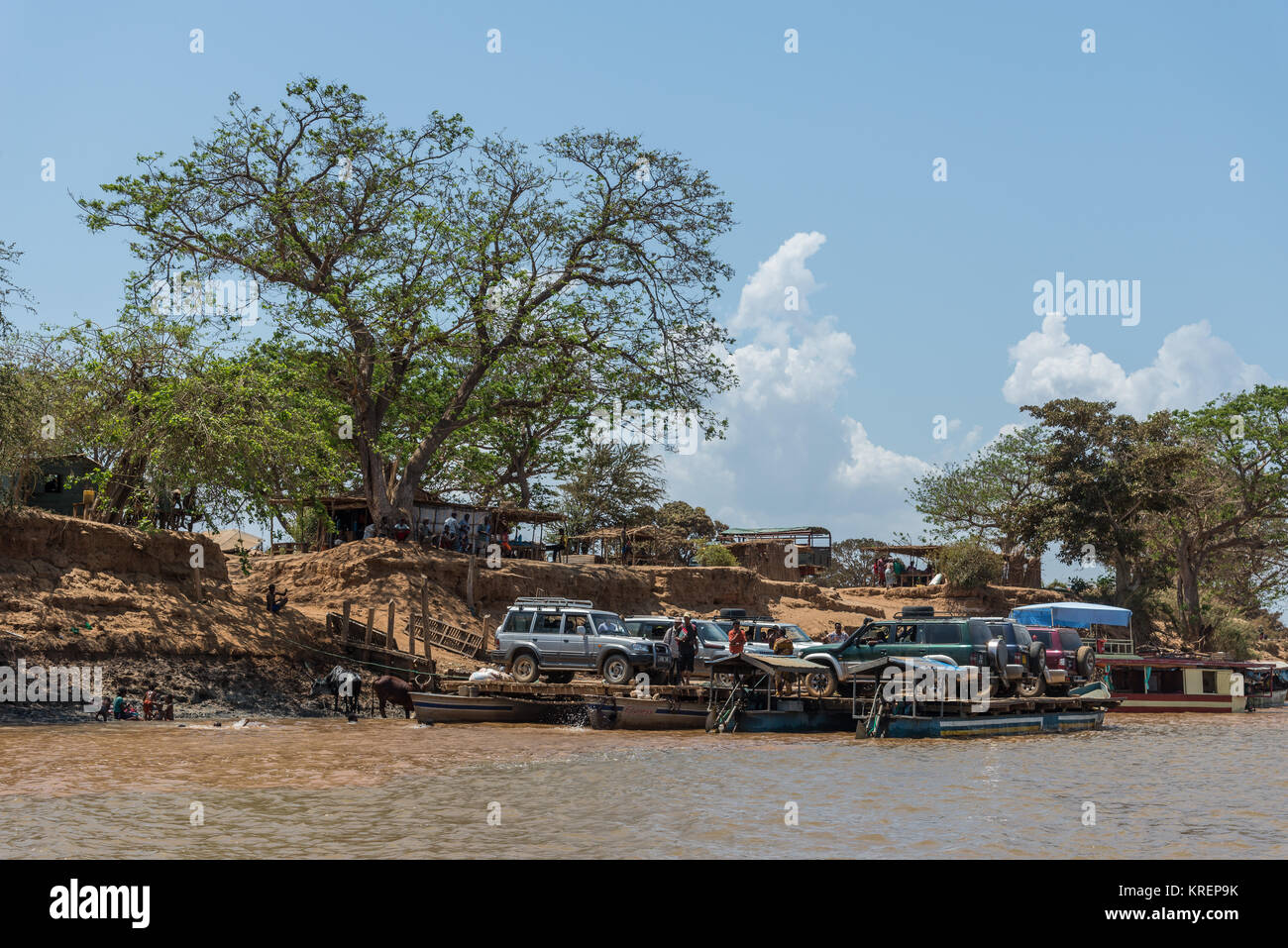 Suv e passeggeri tra il traffico intenso presso il porto dei traghetti di Mania fiume. Madagascar, Africa. Foto Stock