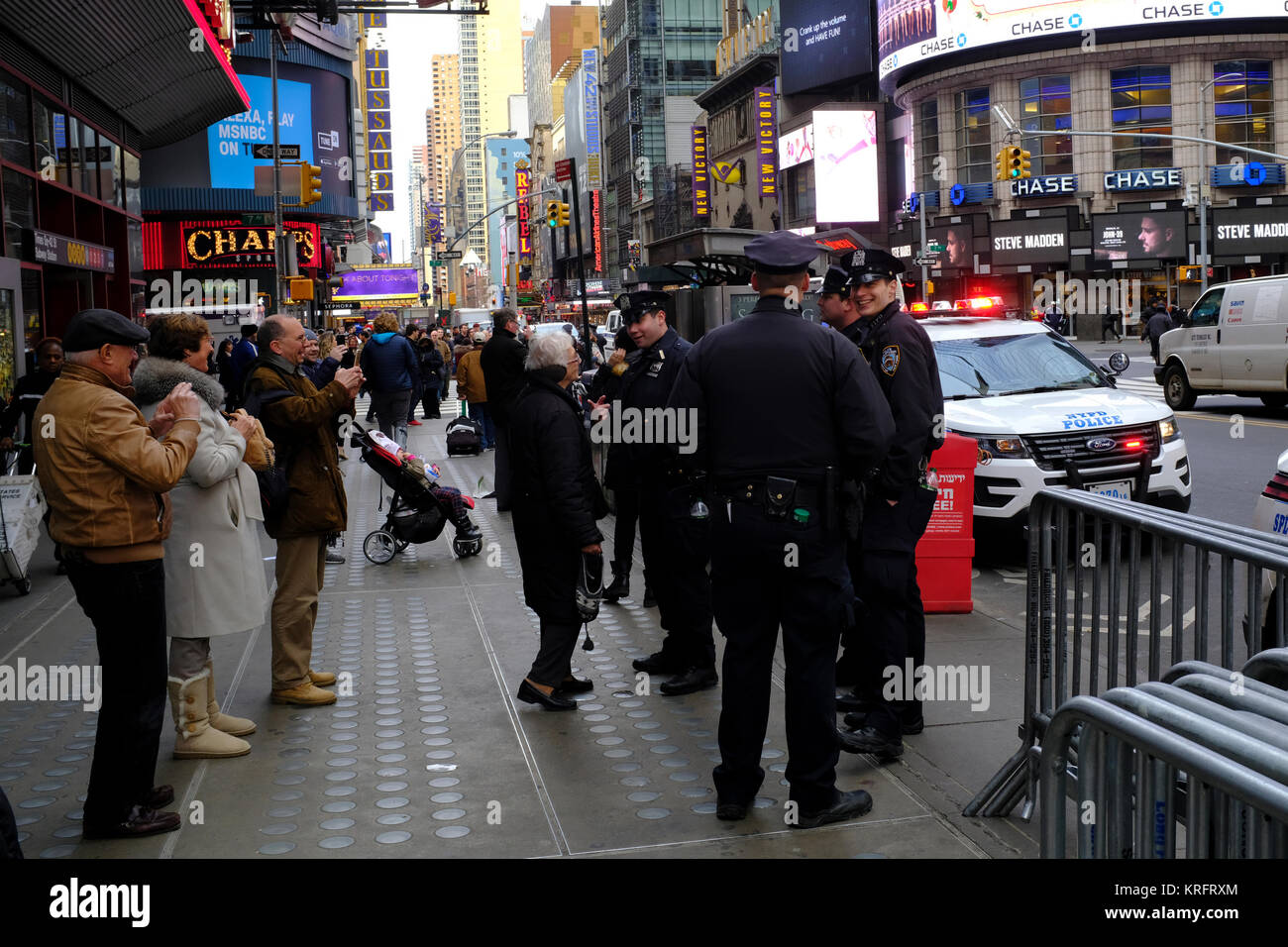 A New York City funzionario di polizia dà indicazioni per un pedone nel corso di una intensa giornata di shopping nella città di New York Foto Stock