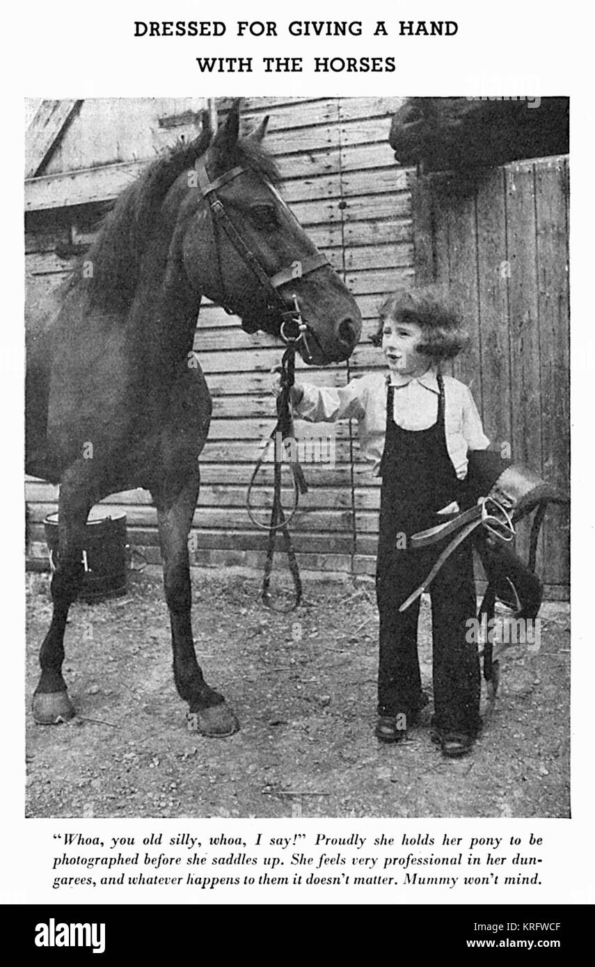Una bambina, modellazione alcuni salopette da maglia, regge le redini di un  cavallo, circa 1941.La salopette da vengono lavorati a maglia in maglia  rasata con cintura nervata e garter stitch girare a