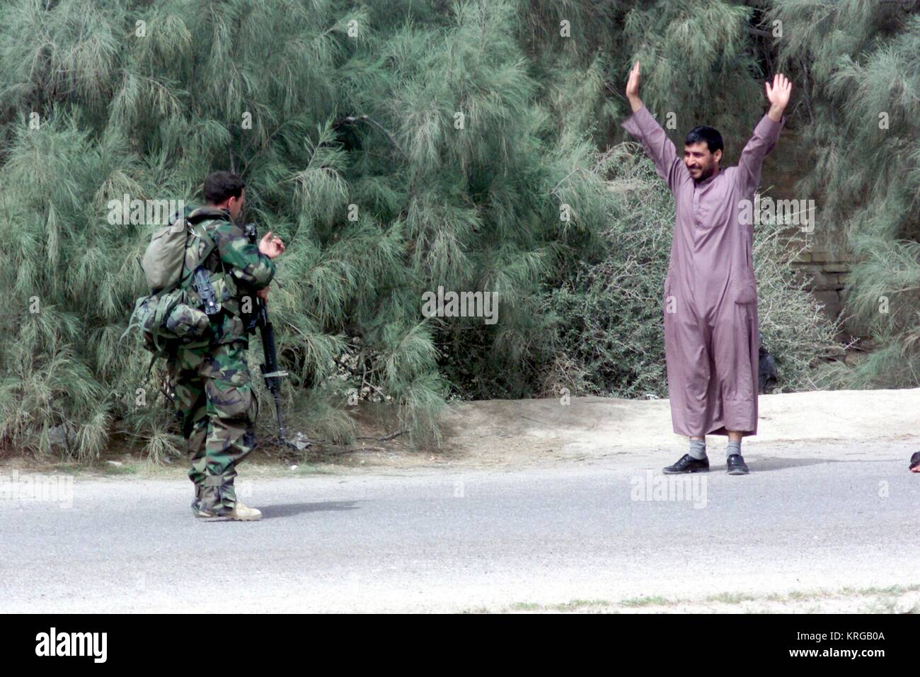 Un cittadino iracheno alza le mani nella rinuncia a U.S. Soldato marino durante l'Operazione Iraqi Freedom Ottobre 25, 2003 vicino a Umm Qasr, Iraq. Foto Stock