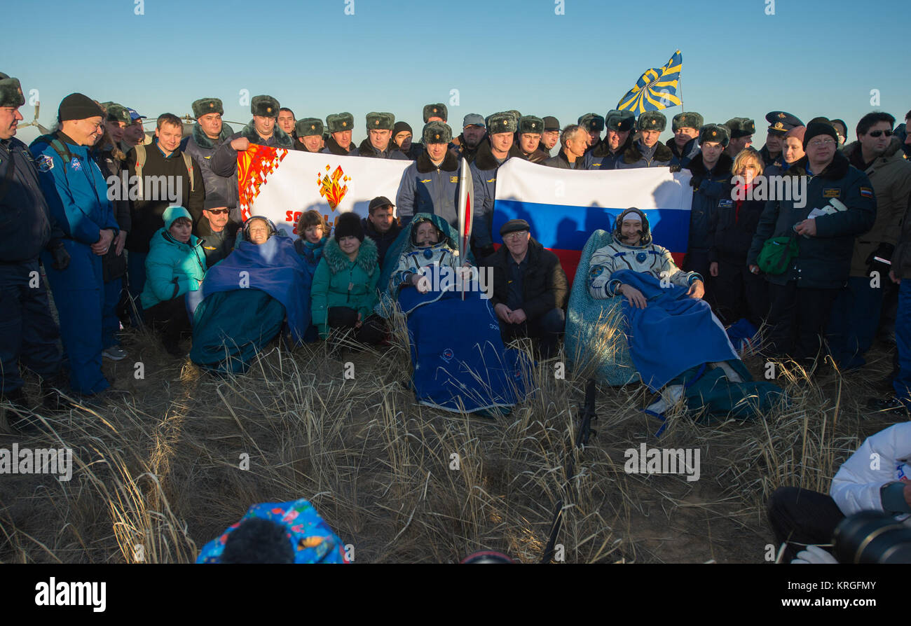 La NASA tecnico di volo Karen Nyberg, sinistra, Expedition 37 comandante Fyodor Yurchikhin di Roscosmos, centro tenendo la torcia olimpica e Agenzia spaziale europea tecnico di volo Luca Parmitano sit in sedie al di fuori della capsula Soyuz a pochi minuti dopo aver atterrato in una zona remota al di fuori della città di Zhezkazgan, Kazakistan, lunedì, nov. 11, 2013. La torcia olimpica è stata lanciata con l'equipaggio della Expedition 38 alla stazione spaziale internazionale il 7 novembre. Si è passati da un modulo al successivo e ha avuto il suo primo spacewalk il 9 Novembre con due cosmonauti russi come parte del suo international Foto Stock