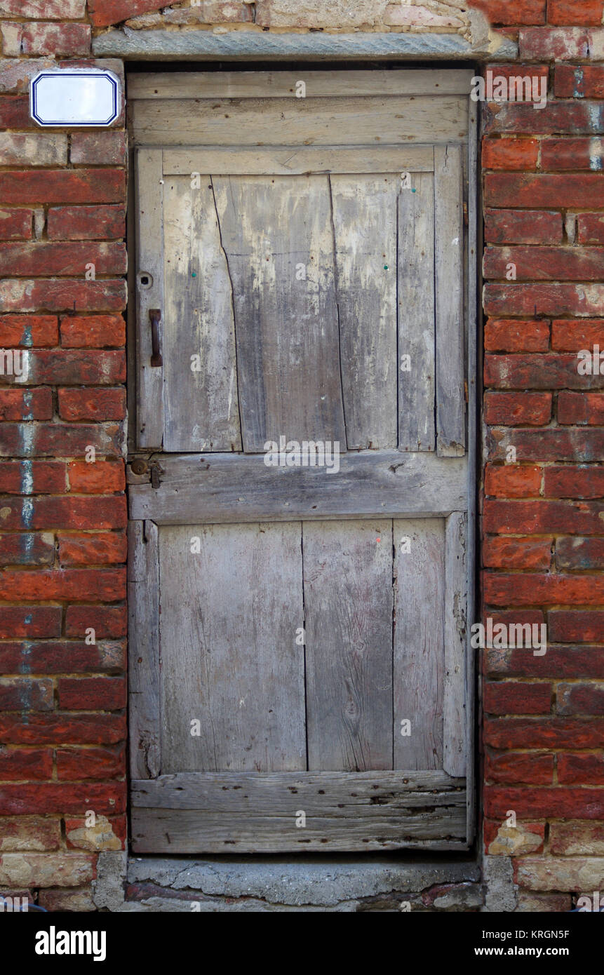 Vecchia porta di legno di antico edificio in mattoni Foto Stock