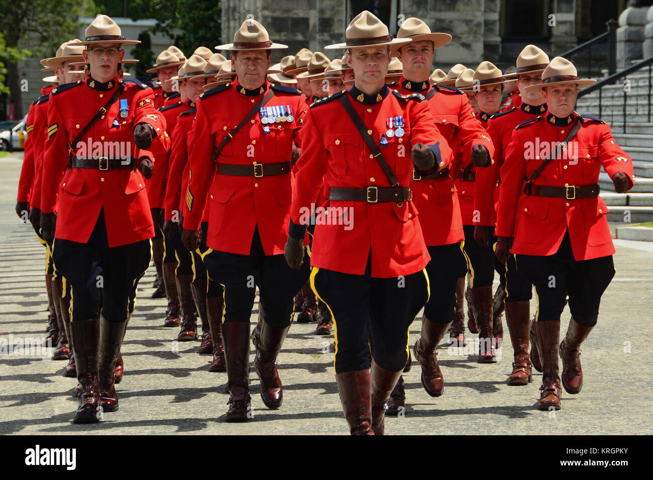 RCMP poliziotti marciando nel tempo verso il basso il percorso in onore dei caduti ufficiali. Foto Stock