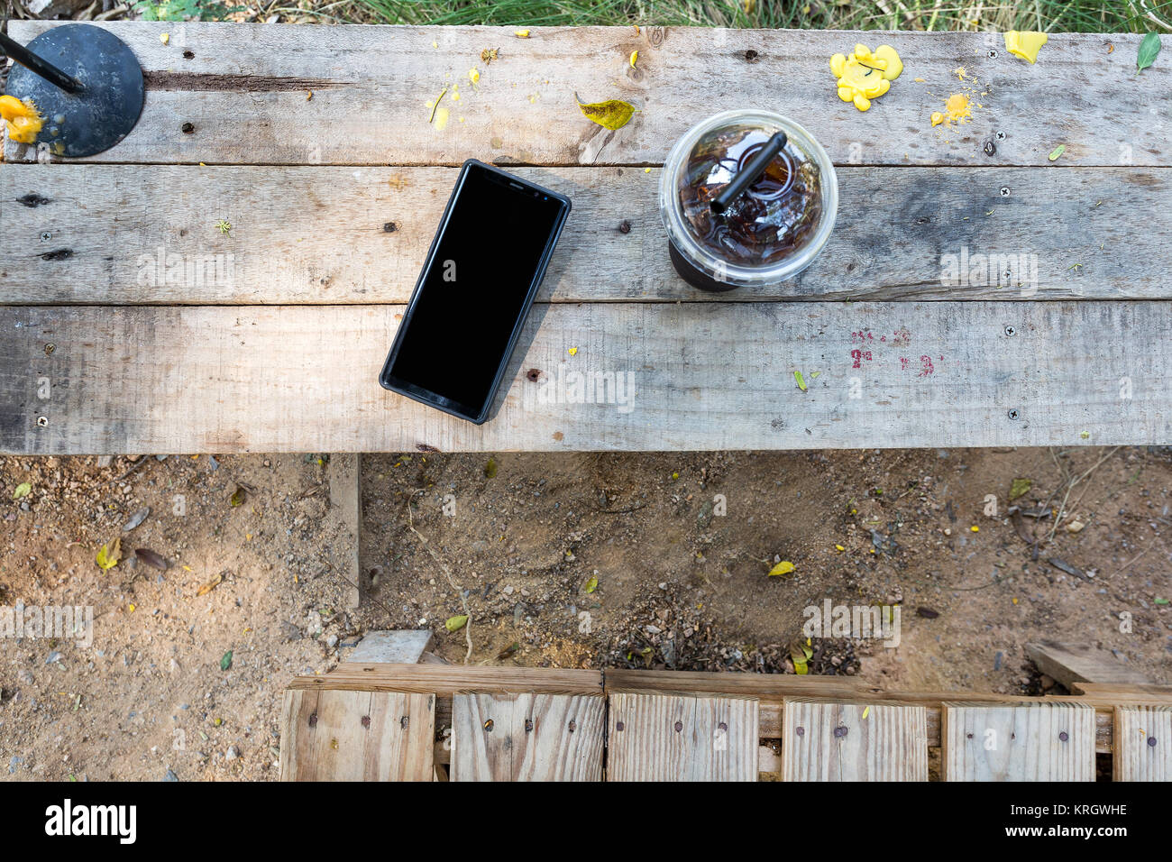 Tempo di rilassarsi con il telefono cellulare e la bevanda fredda sul tavolo in legno stile di vita nella natura Foto Stock