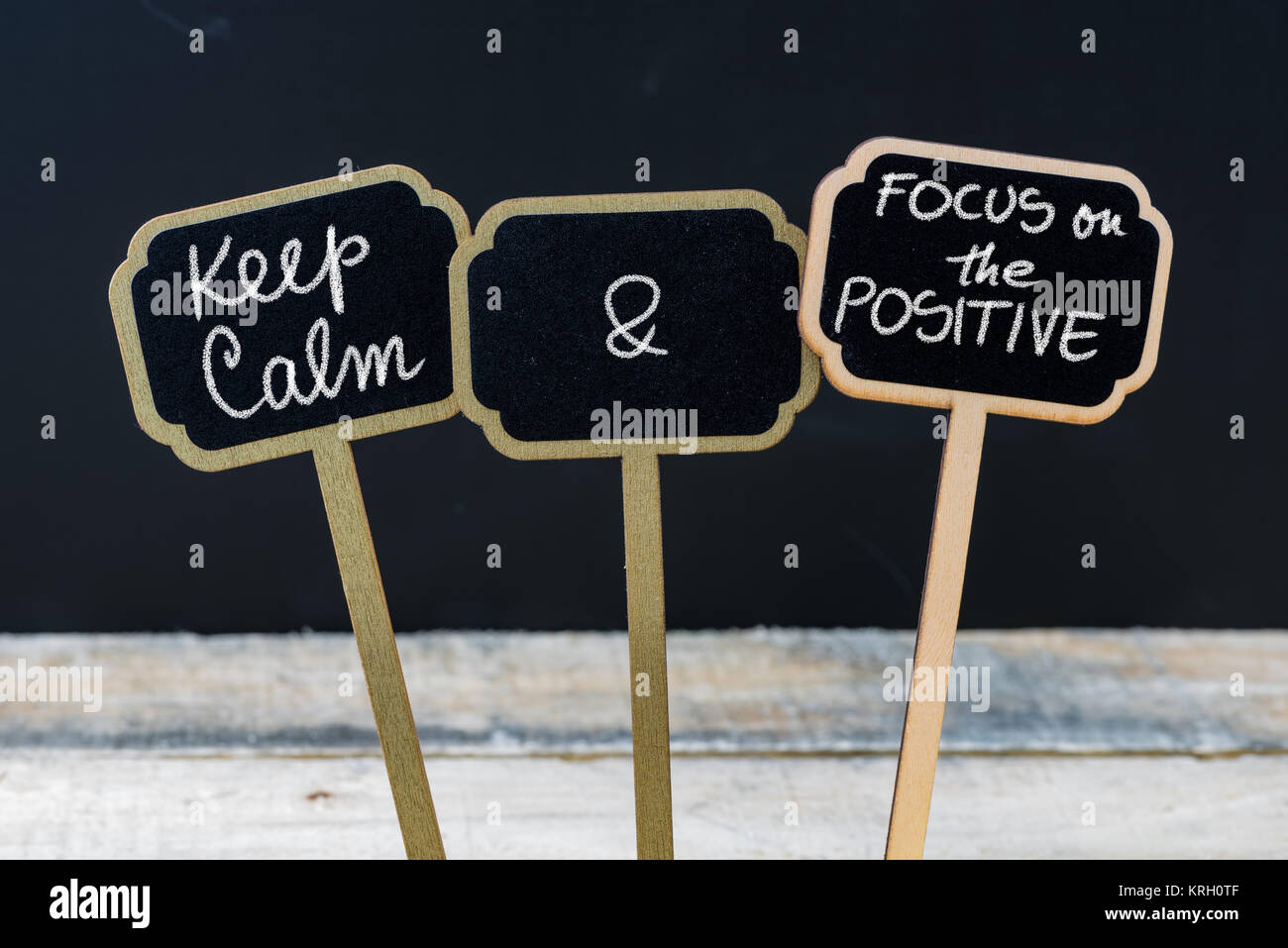 Mantenere la calma e concentrarsi sul messaggio positivo scritto con gesso su mini etichette di Blackboard Foto Stock