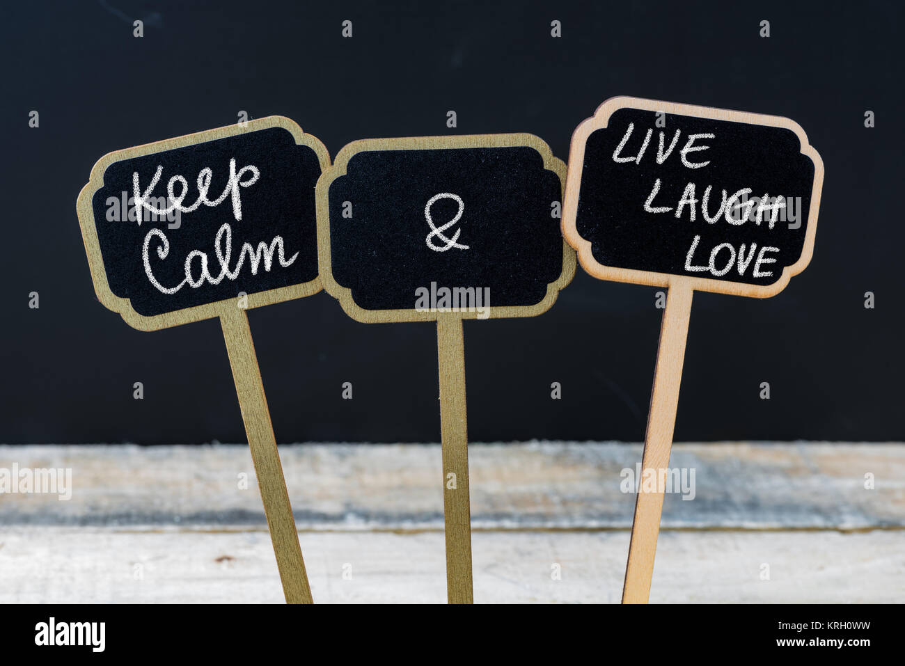 Mantenere la calma e a vivere ridere amore messaggio scritto con un gessetto su mini etichette di Blackboard Foto Stock