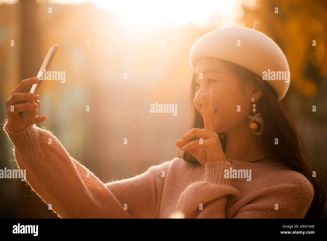 Sorridente donna graziosa tenendo selfies su un giorno in autunno Foto Stock