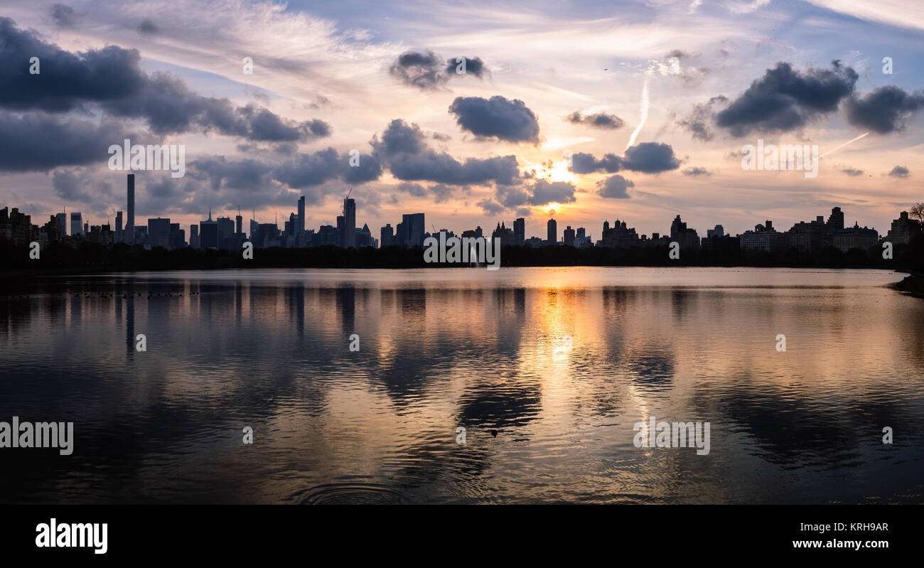 La vista al tramonto nel mese di novembre in tutta l'Jaqueline Kennedy Onassis serbatoio nel Central Park di New York guardando verso il Midtown e Hell's Kitchen Foto Stock