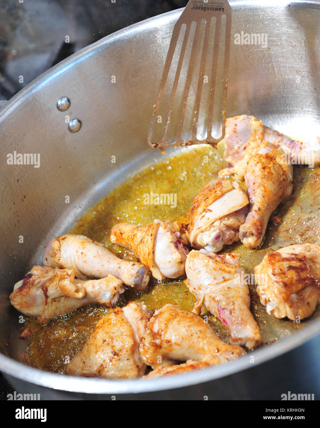 Rosolate il pollo tagliato a pezzi in una padella sautée Foto Stock