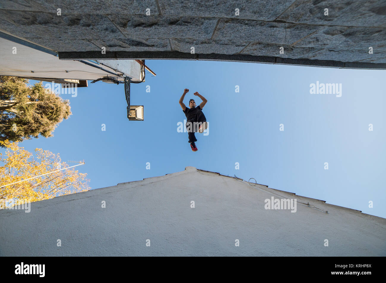 Giovane uomo facendo impressionante parkour saltare da un tetto all'altro. Foto Stock