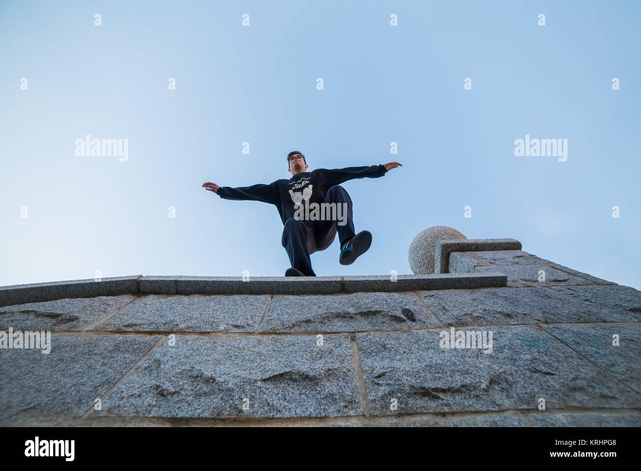 Giovane uomo facendo impressionante parkour saltare da una parete a terra. Foto Stock