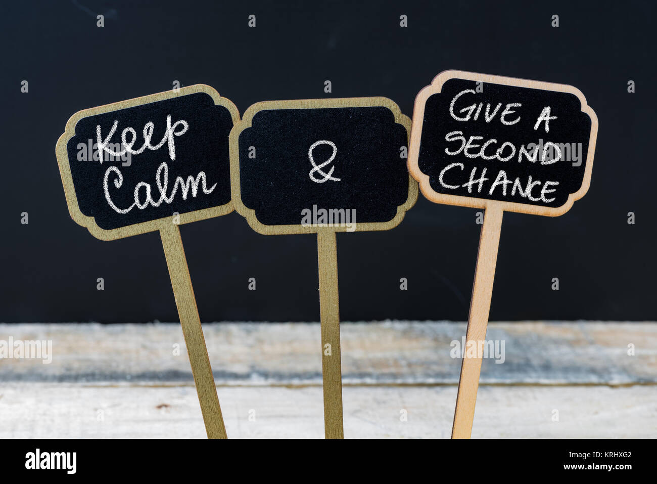 Mantenere la calma e di dare una seconda possibilità messaggio scritto con un gessetto su mini etichette di Blackboard Foto Stock