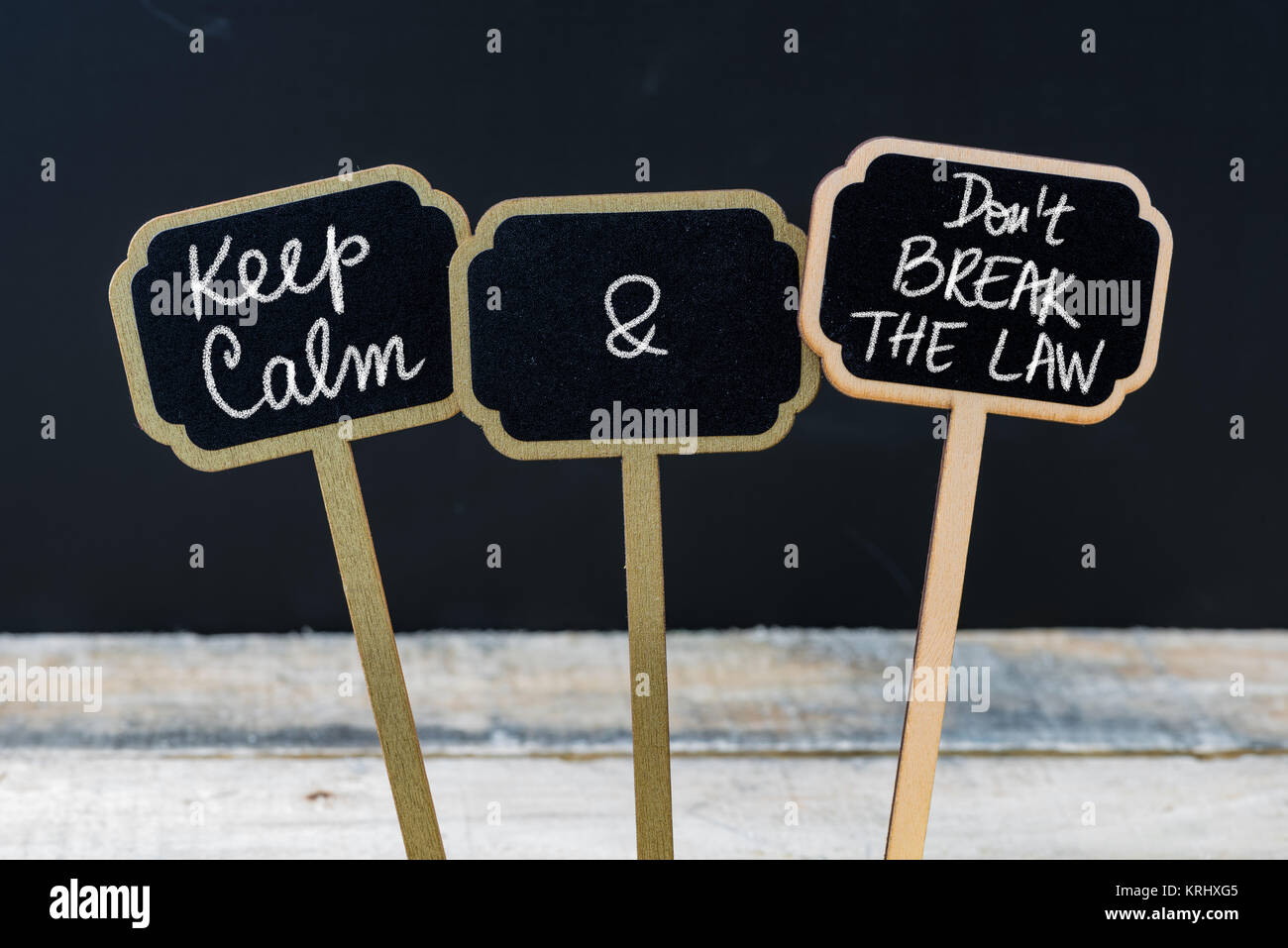 Mantenere la calma e a non violare la legge messaggio scritto con un gessetto su mini etichette di Blackboard Foto Stock