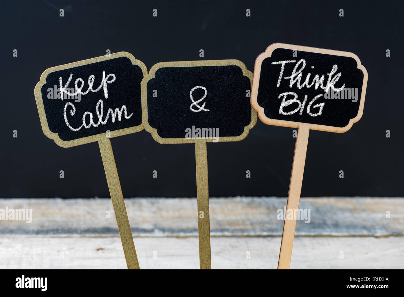 Mantenere la calma e pensare in grande messaggio scritto con un gessetto su mini etichette di Blackboard Foto Stock