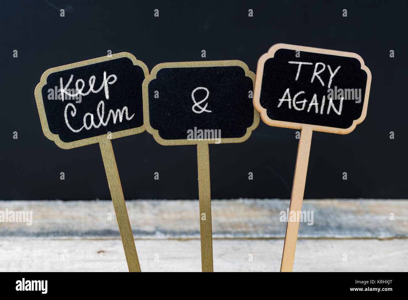 Mantenere la calma e provare di nuovo messaggio scritto con un gessetto su mini etichette di Blackboard Foto Stock