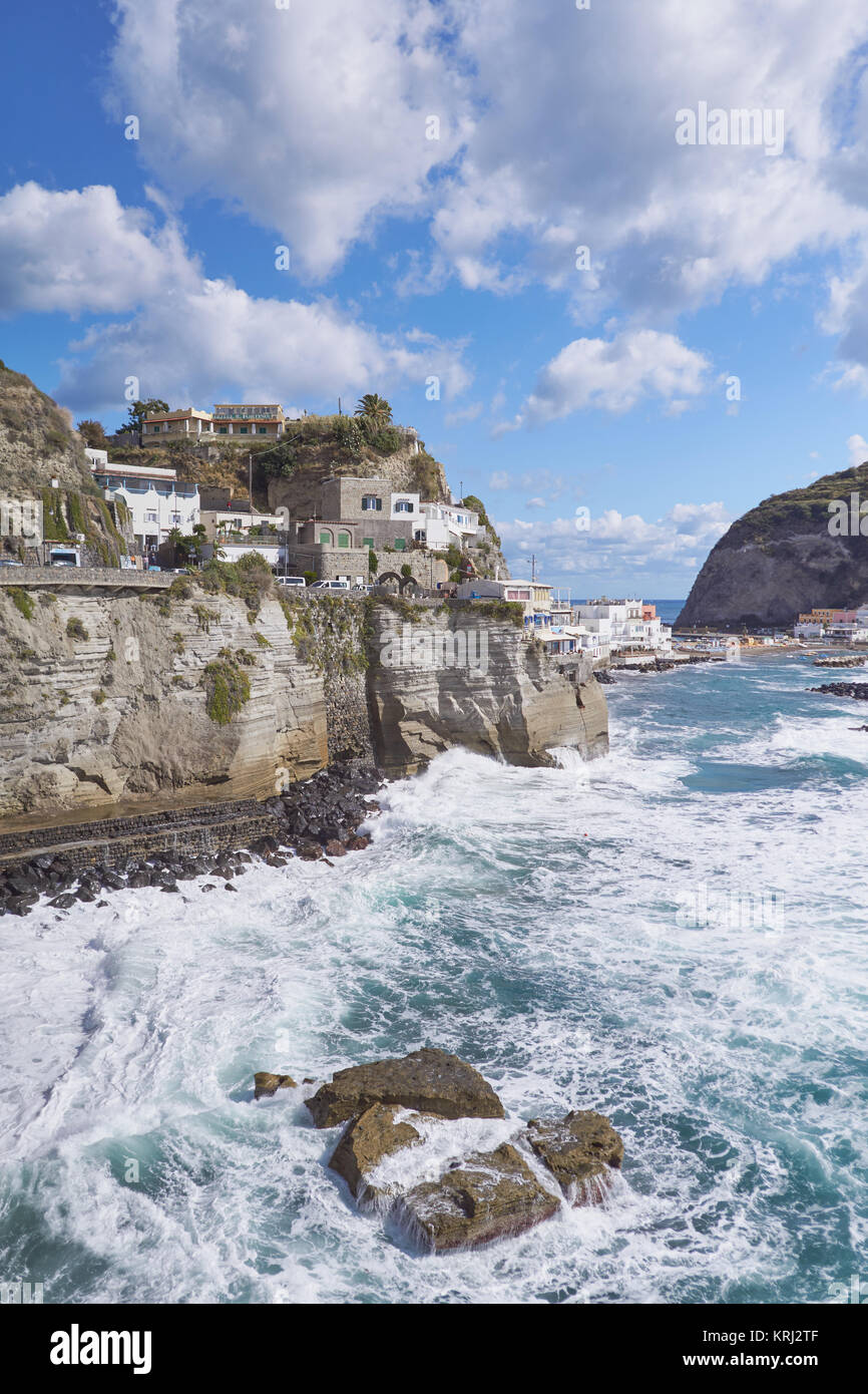 Famoso Sant'Angelo Village sulle scogliere sul mare, selvaggio con onde che si infrangono contro gli scogli - Ischia, Italia Foto Stock