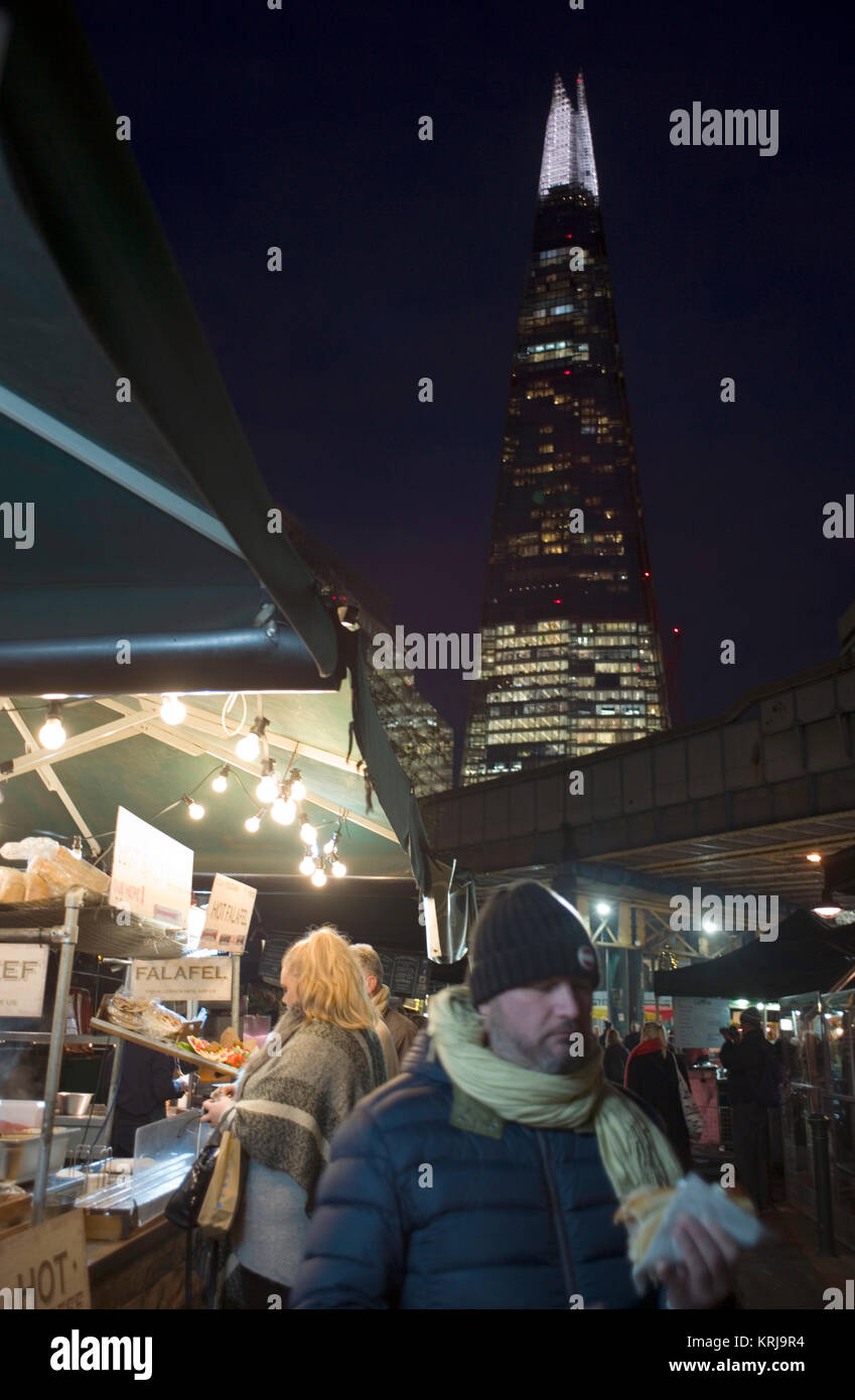 Il grattacielo Shard torreggia sopra banchi di cibo al calar della sera su Borough Market, a Londra, Gran Bretagna Dicembre 19, 2017 Foto Stock