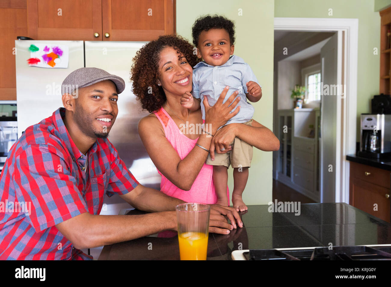 Ritratto di sorridere razza mista giovane e baby figlio in cucina Foto Stock