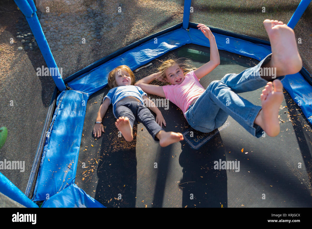 Caucasian fratello e sorella di rimbalzare sul trampolino Foto Stock