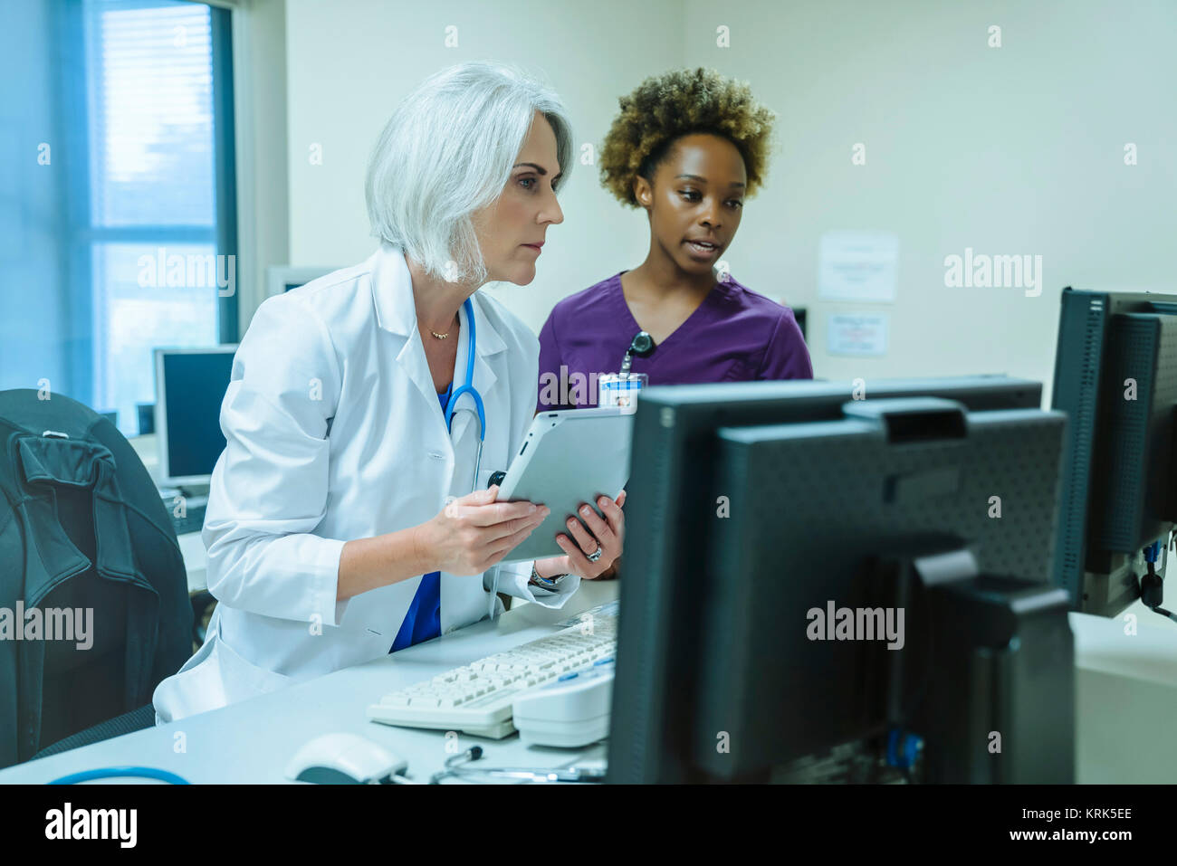 Medico e infermiere con tavoletta digitale e il computer Foto Stock
