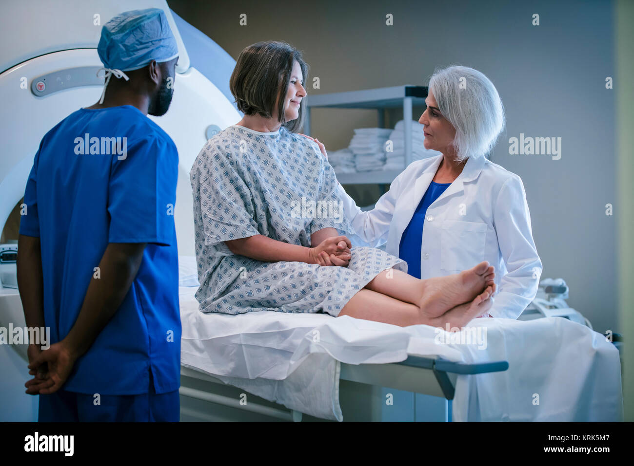 Medico e tecnico di parlare al paziente a scanner Foto Stock