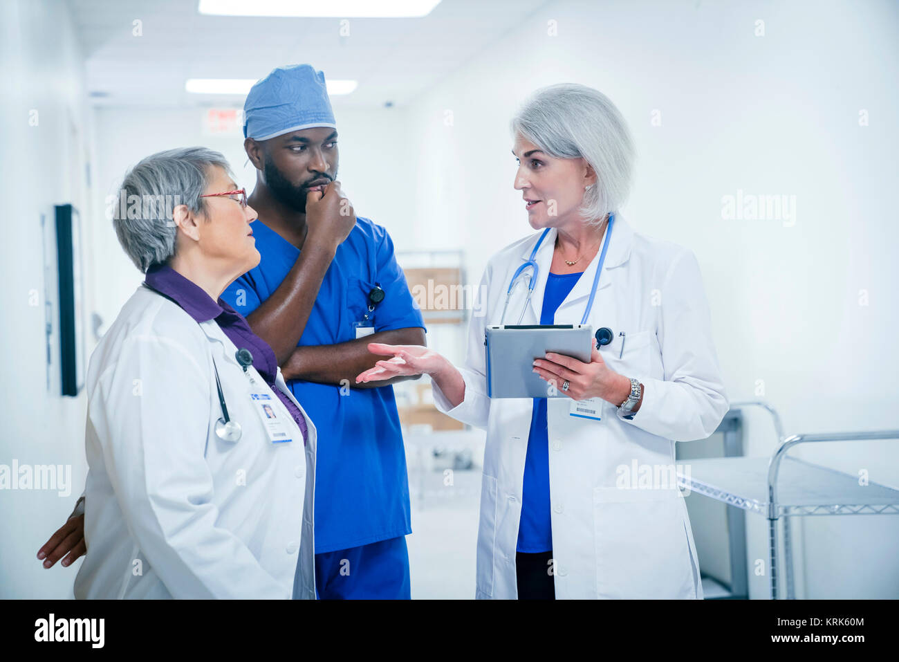 Medici e infermieri a discutere di tavoletta digitale Foto Stock