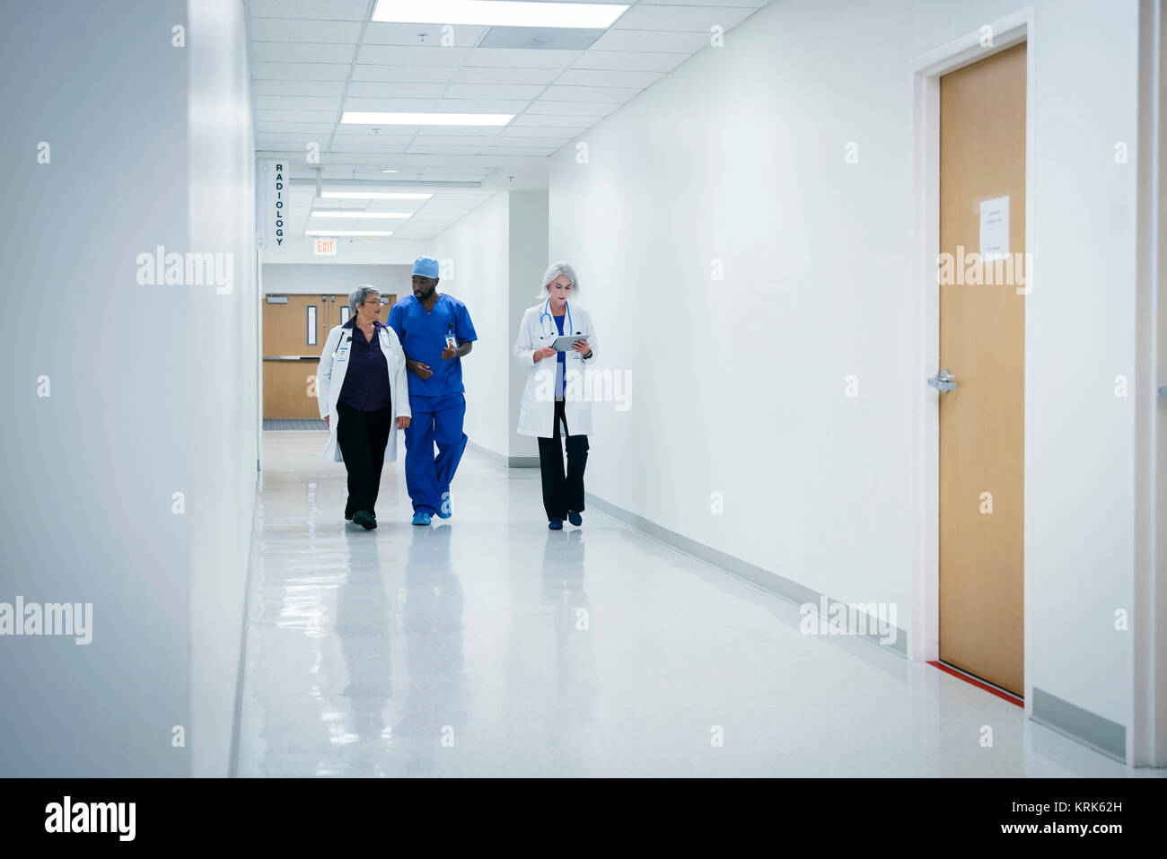 Medici e infermieri a piedi in ospedale Foto Stock