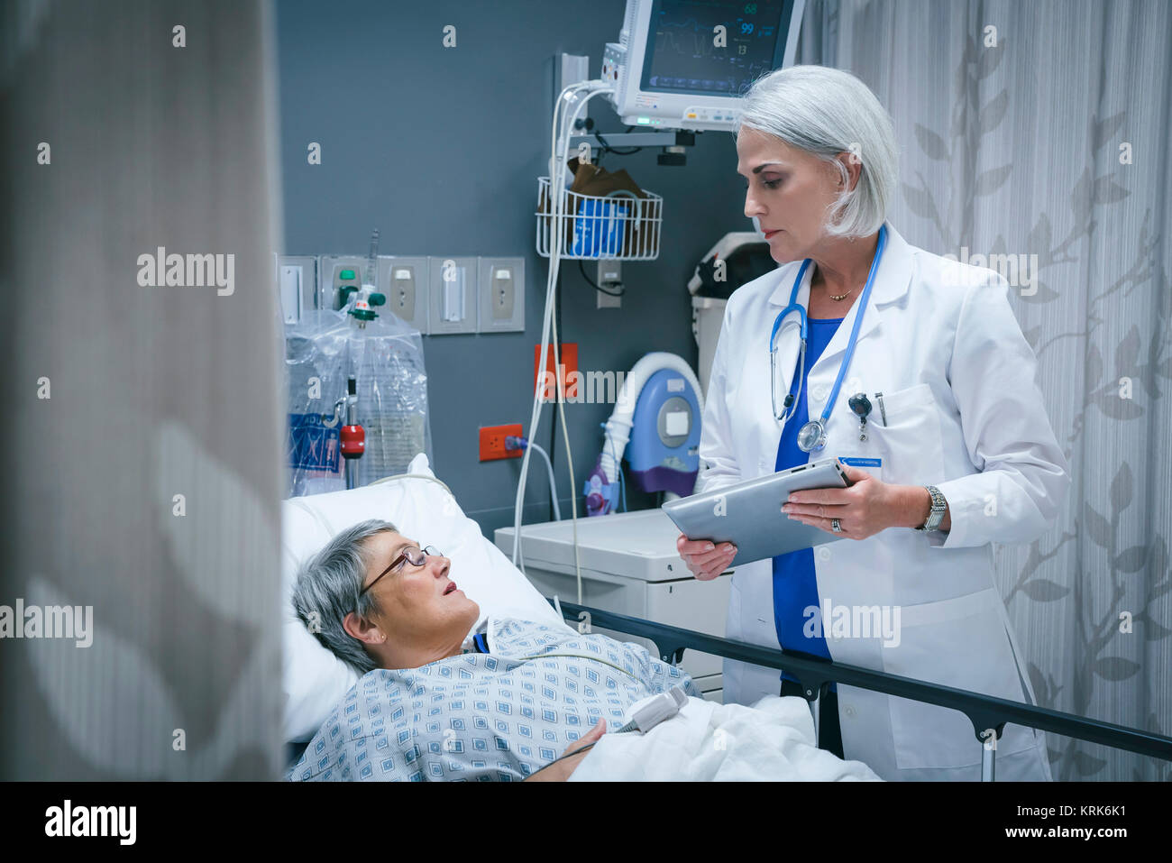 Medico con tavoletta digitale parlando al paziente Foto Stock