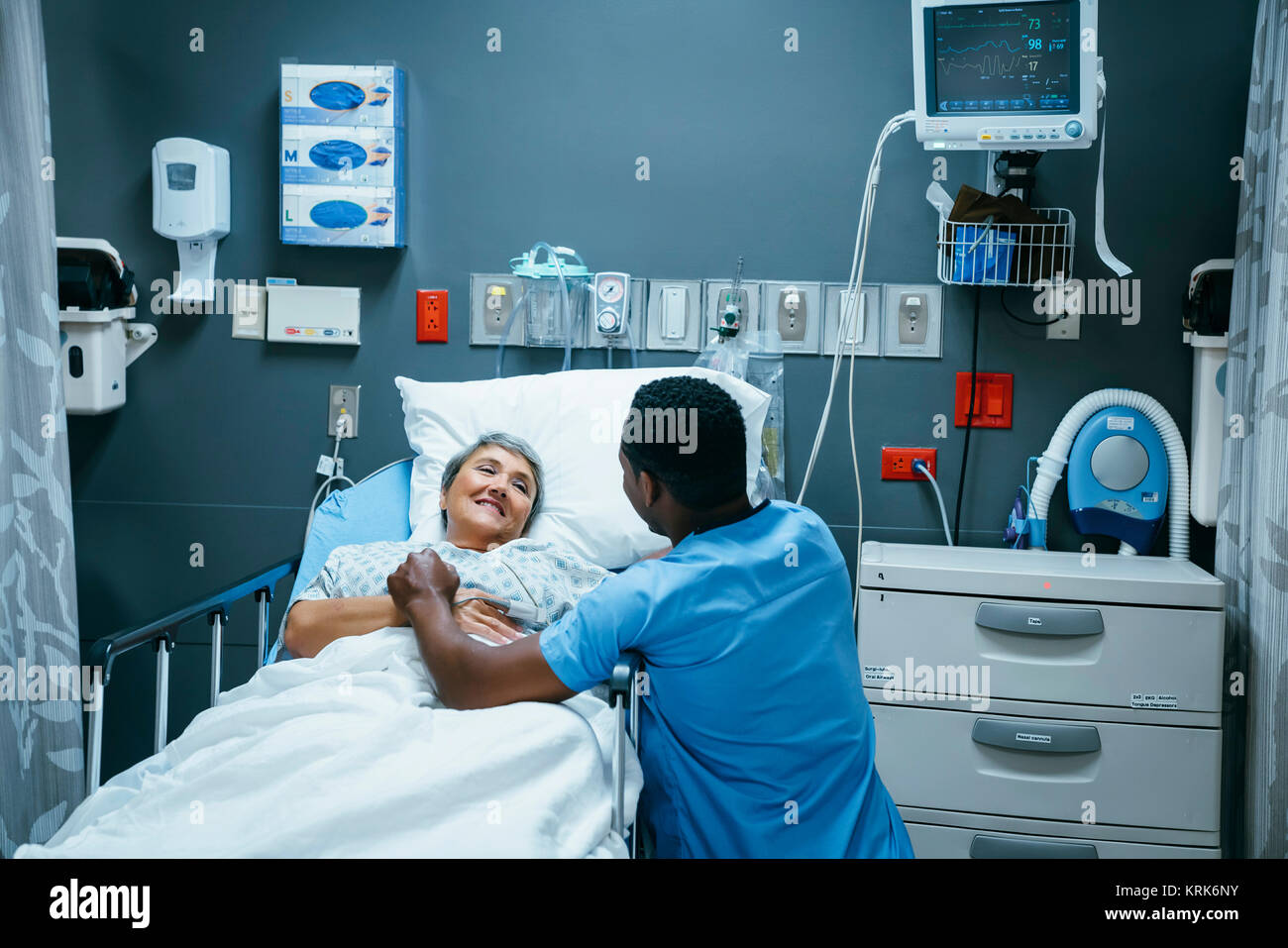 Infermiere parlando al paziente nel letto di ospedale Foto Stock