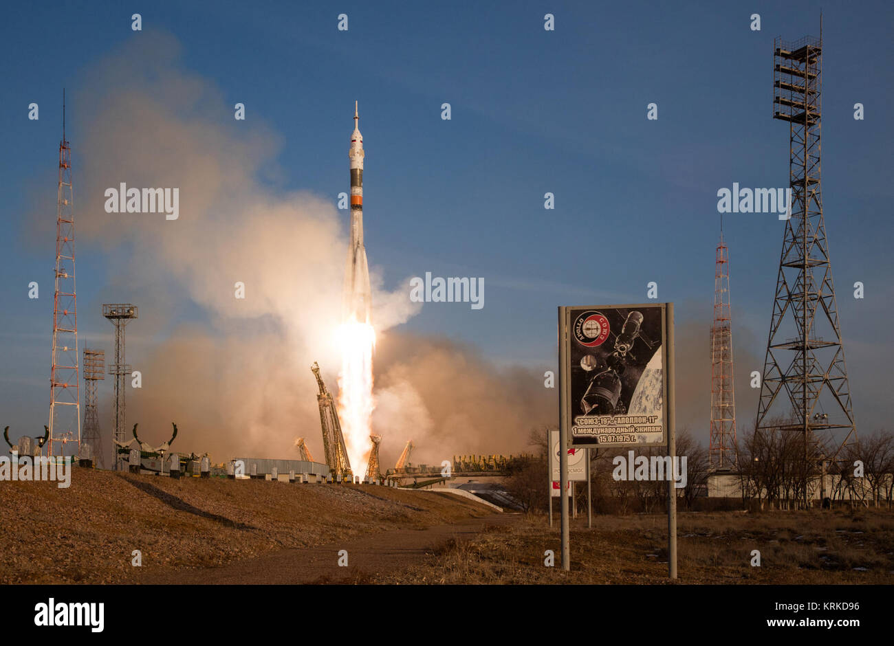 Con un segno per la commemorazione del 1975 Apollo-Soyuz missione in primo piano, la Soyuz TMA-19M veicolo spaziale lanciato dal cosmodromo di Baikonur in Kazakistan, Martedì, Dicembre 15, 2015, inviando Expedition 46 Tecnico di volo Tim Kopra della NASA, Soyuz Commander Yuri Malenchenko di l'agenzia Spaziale Federale Russa Roscosmos () e tecnico di volo Tim Peake di ESA (Agenzia spaziale europea) in orbita per la partenza di sei mesi di missione sulla Stazione spaziale internazionale. Photo credit: (NASA/Joel Kowsky) Expedition 46 di lancio (NHQ201512150033) Foto Stock