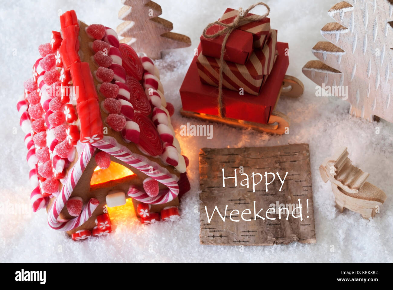 Etichetta con testo in inglese Happy Weekend. Gingerbread House sulla neve con decorazione di Natale come gli alberi e alci. In slitta con i regali di Natale o presenta. Foto Stock