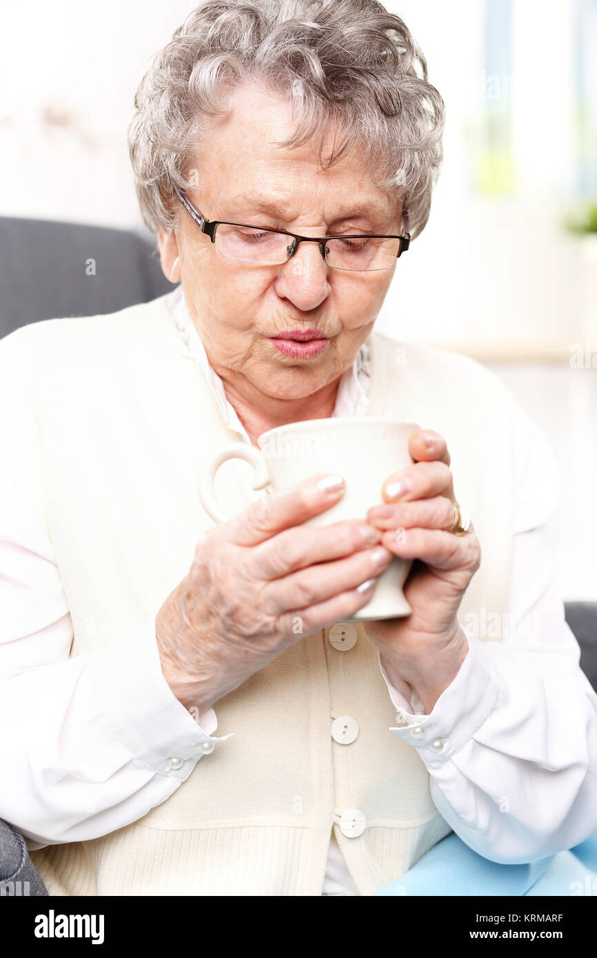 La vecchia signora di bere un infuso di erbe. la nonna kit primo soccorso,l'infusione di erbe aromatiche. Foto Stock