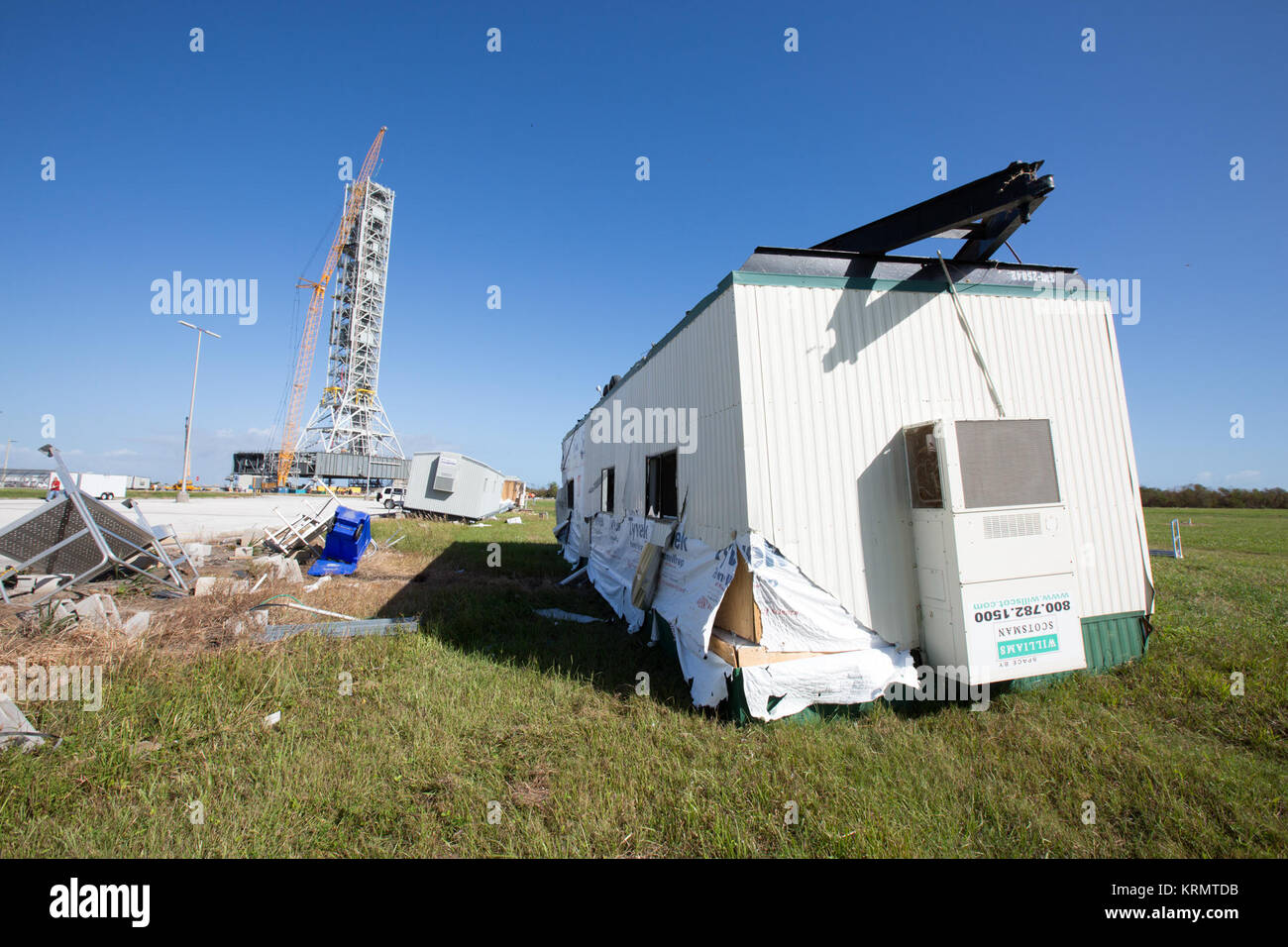 Una costruzione danneggiato il rimorchio e diversi pezzi di detriti associati, conseguenze dell'Uragano Matteo, sono visibili nella parte anteriore del mobile Launcher del Launch Complex 39 area al NASA Kennedy Space Center in Florida. Le valutazioni e le riparazioni sono in corso in varie strutture e servizi attraverso la spaceport, parte dell'attività in corso di recupero dall'uragano Matteo, che passava ad est di Kennedy il 6 ottobre e 7, 2016. Il centro ha ricevuto alcuni isolati tetto danni, supporto danneggiato edifici, a pochi abbattuto le linee di potenza e un numero limitato di intrusione di acqua. Spiaggia di erosione si è verificato anche, sebbene la Foto Stock