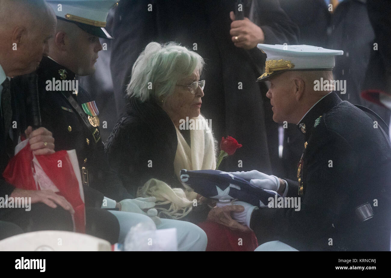 Annie Glenn, moglie di ex astronauta e U.S. Il senatore John Glenn riceve ripiegata di bandiera americana dal comandante dell'U.S. Marine Corps, il generale Robert B. Neller, durante un graveside inumazione cerimonia presso il Cimitero Nazionale di Arlington in Virginia il giovedì, 6 aprile 2017, il giorno in cui Glenn e Annie erano sposati nel 1943. Egli è stato il primo americano in orbita sulla Terra il 20 febbraio 1962, in un periodo di cinque ore di volo a bordo dell'Amicizia 7 veicolo spaziale. In 1998, Glenn ha rotto un altro record riportando allo spazio all'età di 77 sulla navetta spaziale Discovery. Photo credit: (NASA/Aubrey Gemignani) Giovanni G Foto Stock